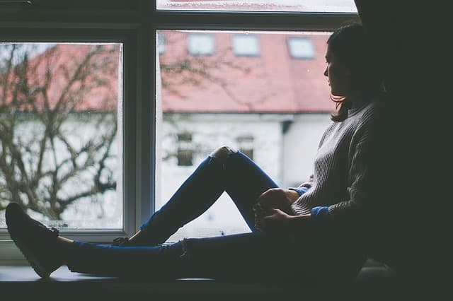 girl sitting in window looking depressed--what is depression?