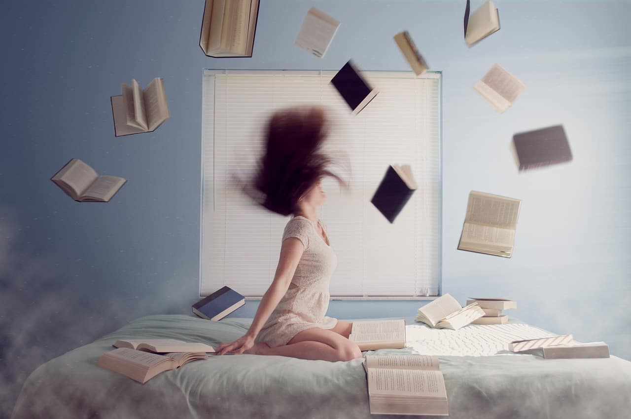 woman with tons of books from the best book clubs and companies