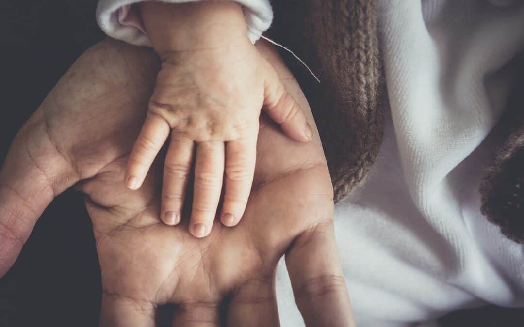 father holding his babies hand