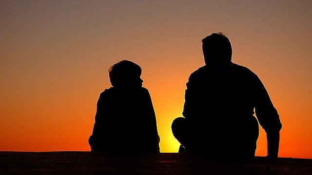 dad and son watching the sunset and discussing "the Book of Dad"